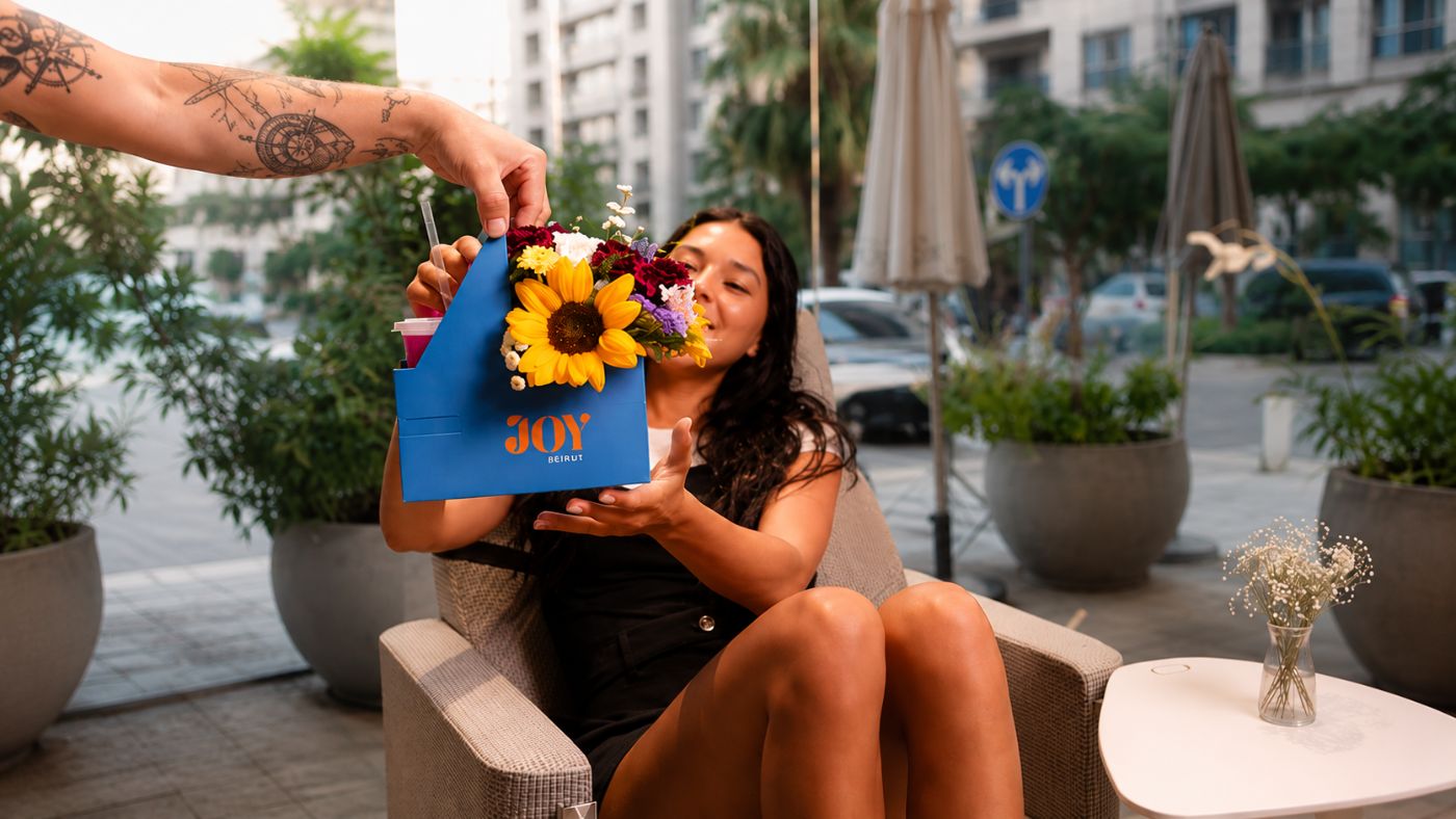 A guest being welcomed with coffee and flowers at Malaya